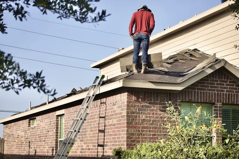 Professional roofer working on a residential roof in East Lawn